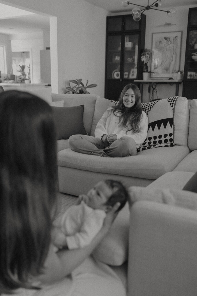 The Robbins family snuggles newborn Rowan on their living room couch during an in-home newborn family session after a home birth.
