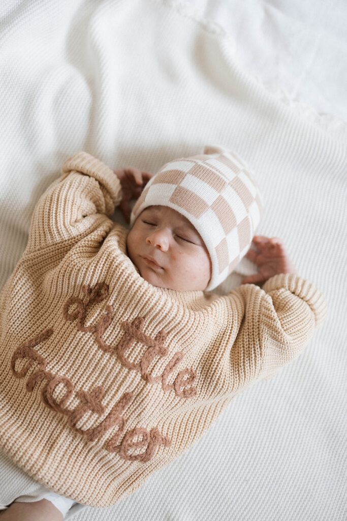 Newborn Rowan peacefully sleeps in a neutral clothes during an in-home family session, photographed in the space where he was born.