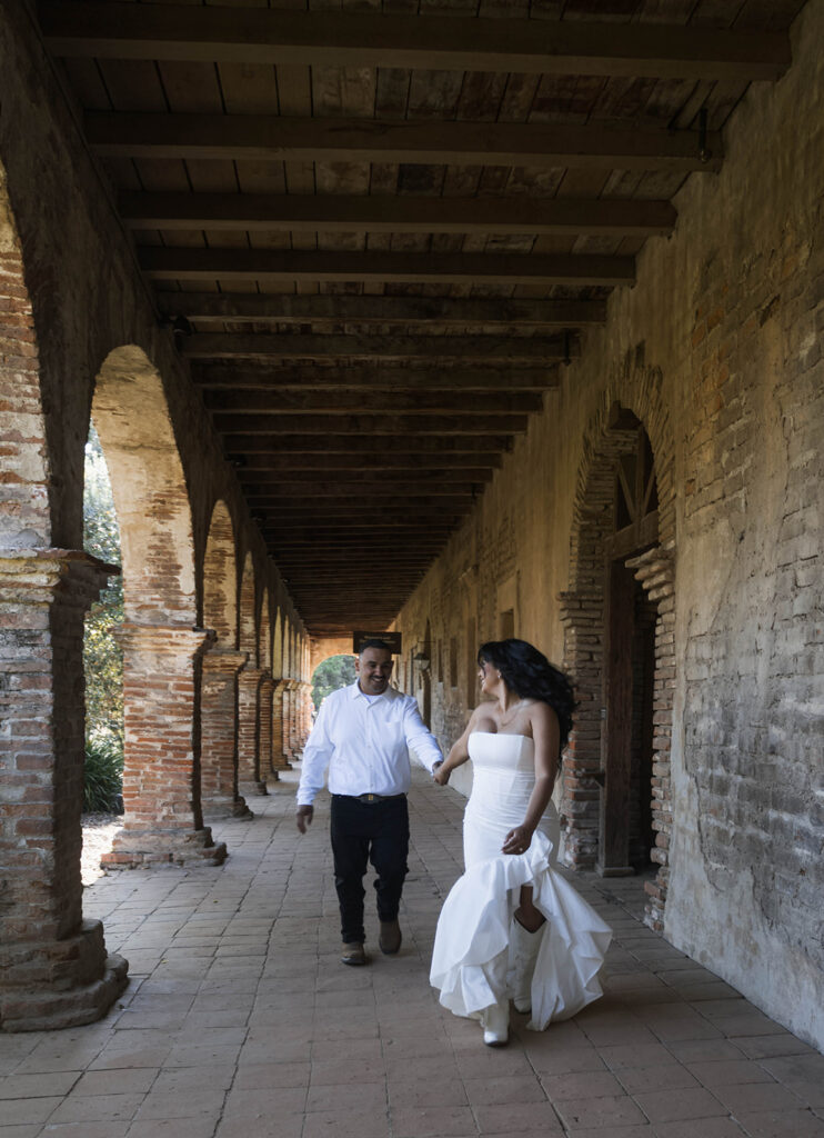 future bride and groom taking western style engagment photos at san juan capistrano mission