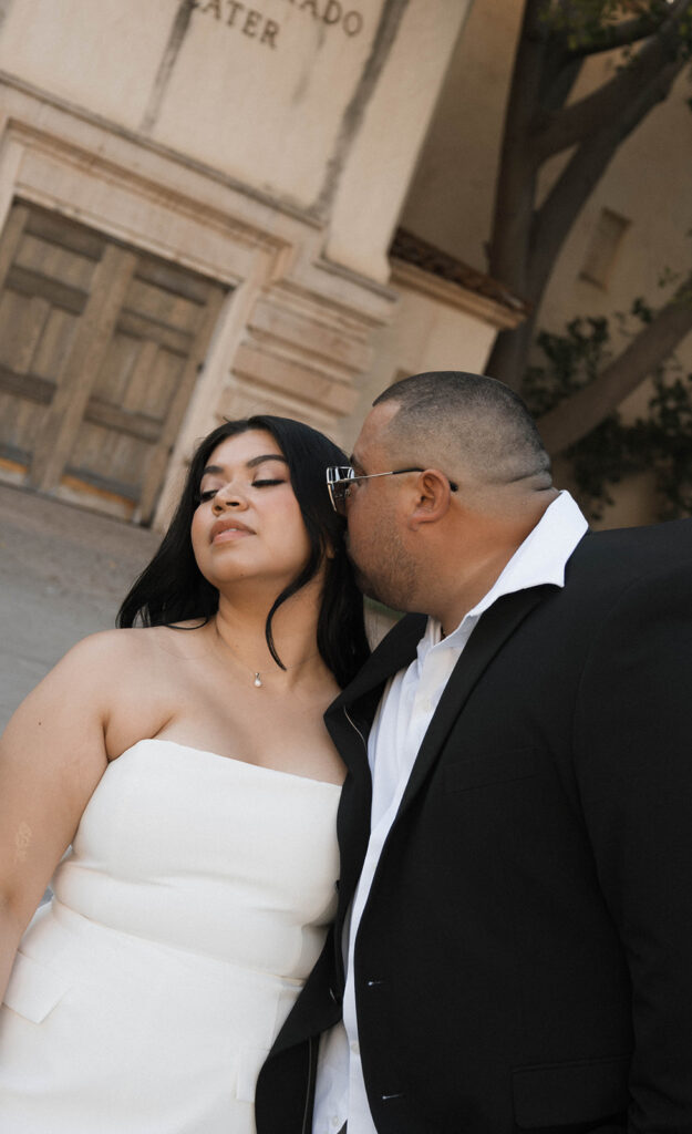 Sabrina and Azor posing in front of a classic vintage car from SD Vintage Rides at Balboa Park, exuding formal glamour.