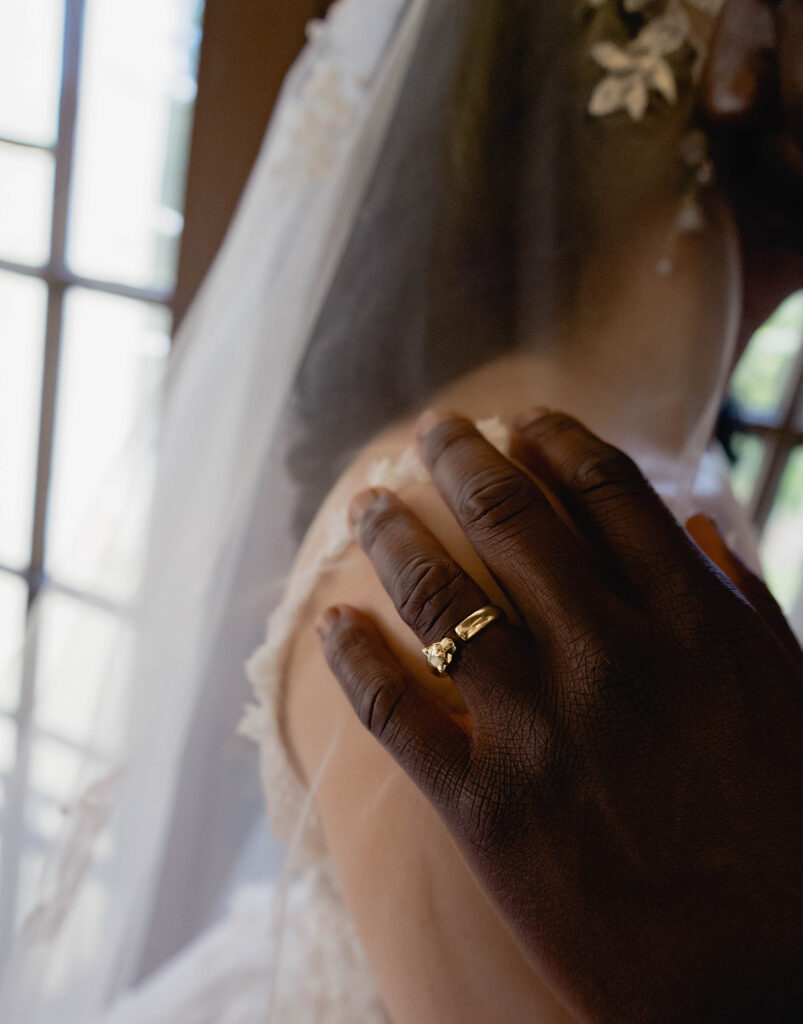 A bride and groom standing together indoors in formal wedding attire.