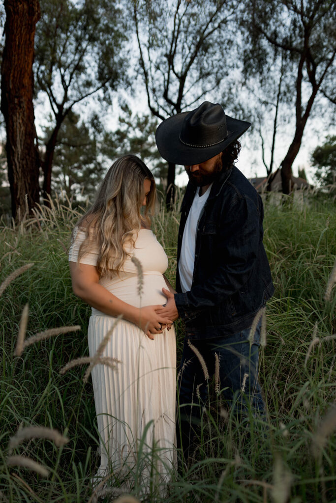 Orange County maternity photographer capturing organic couples maternity session in tall grass with expecting parents
