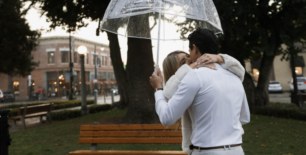 Couple walking through Historic Orange during a rainy engagement session with cinematic, romantic mood