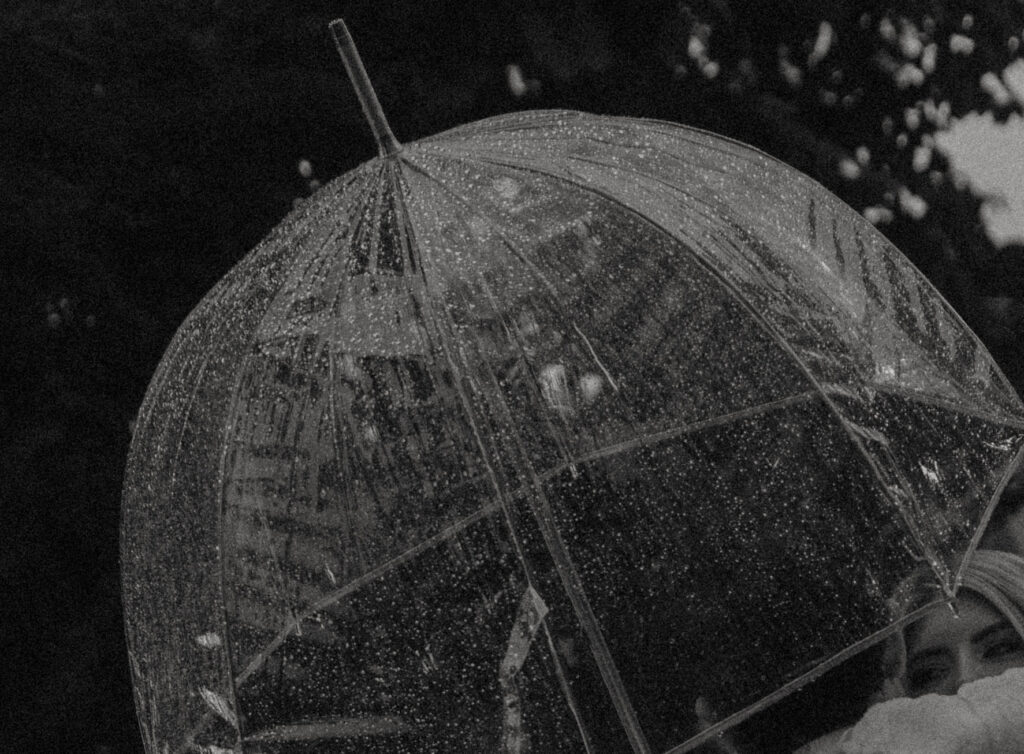 Couple walking through Historic Orange during a rainy engagement session with cinematic, romantic mood