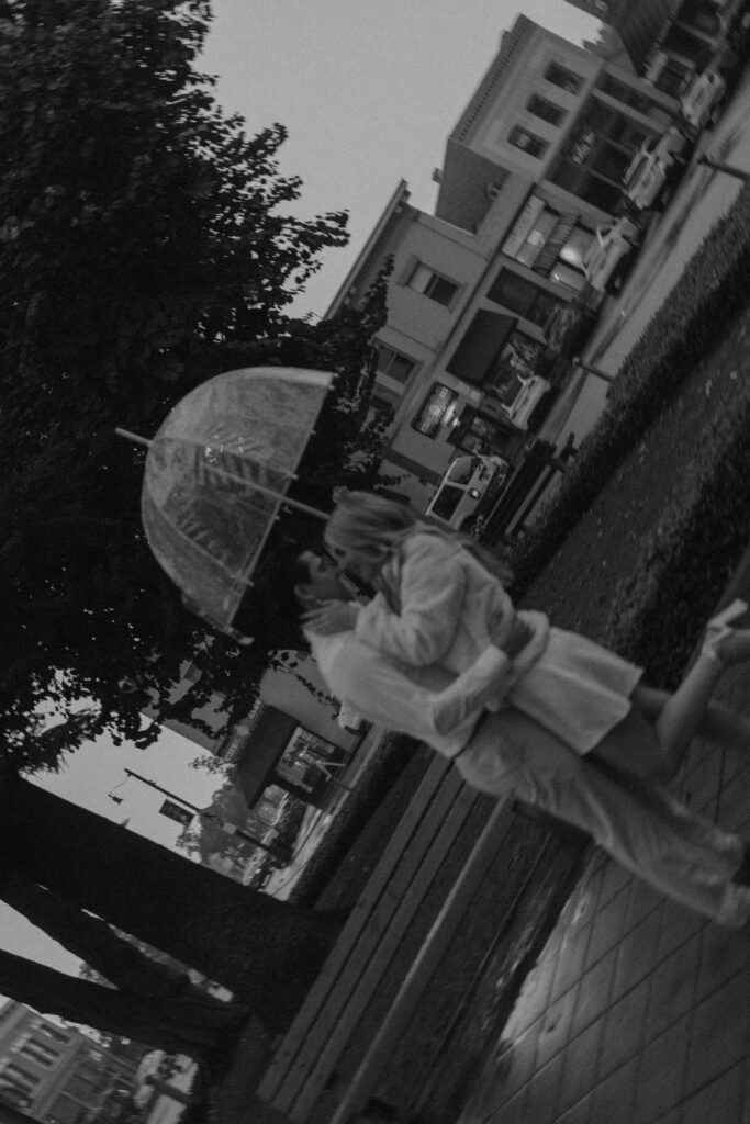 Couple walking through Historic Orange during a rainy engagement session with cinematic, romantic mood