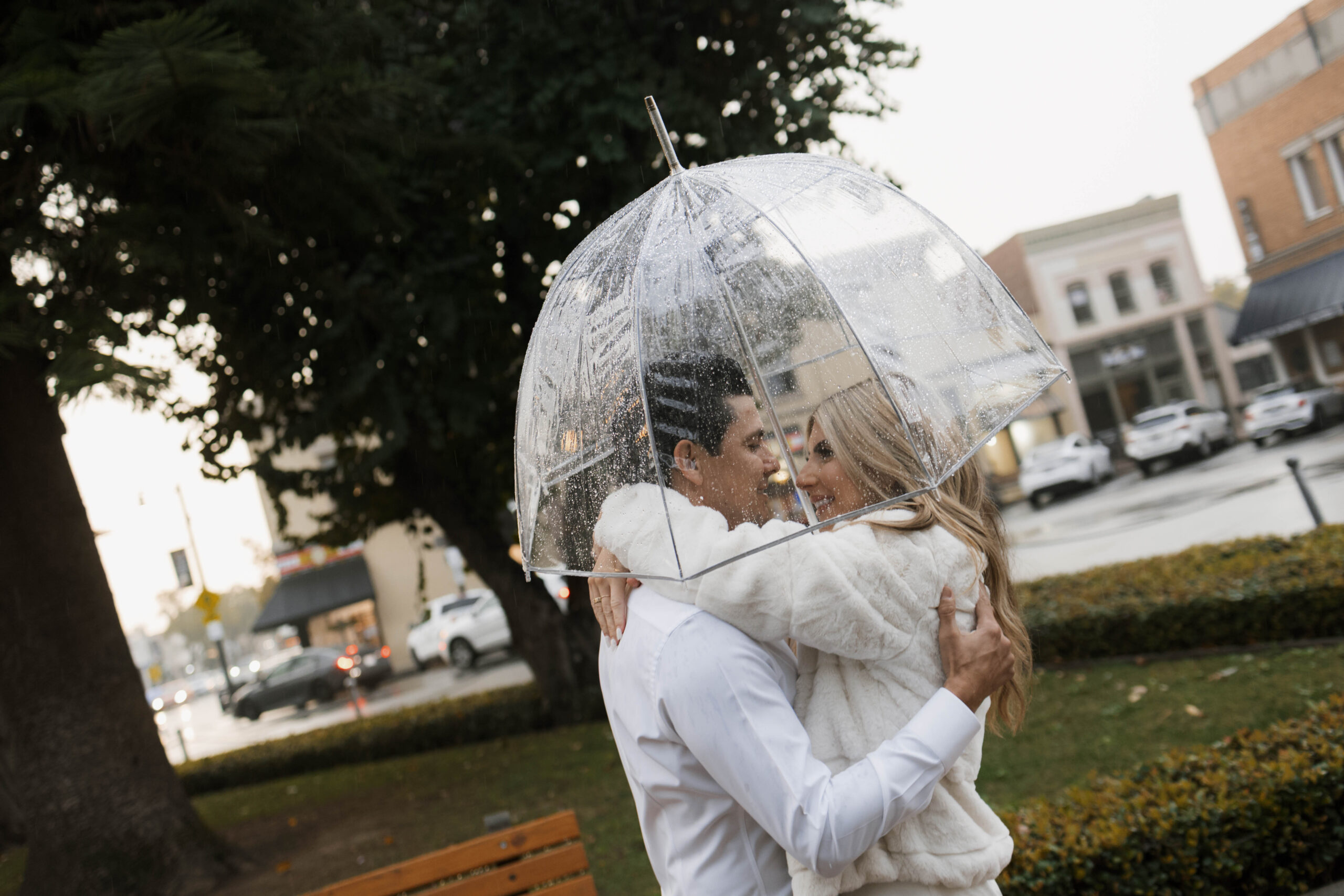 Couple walking through Historic Orange during a rainy engagement session with cinematic, romantic mood