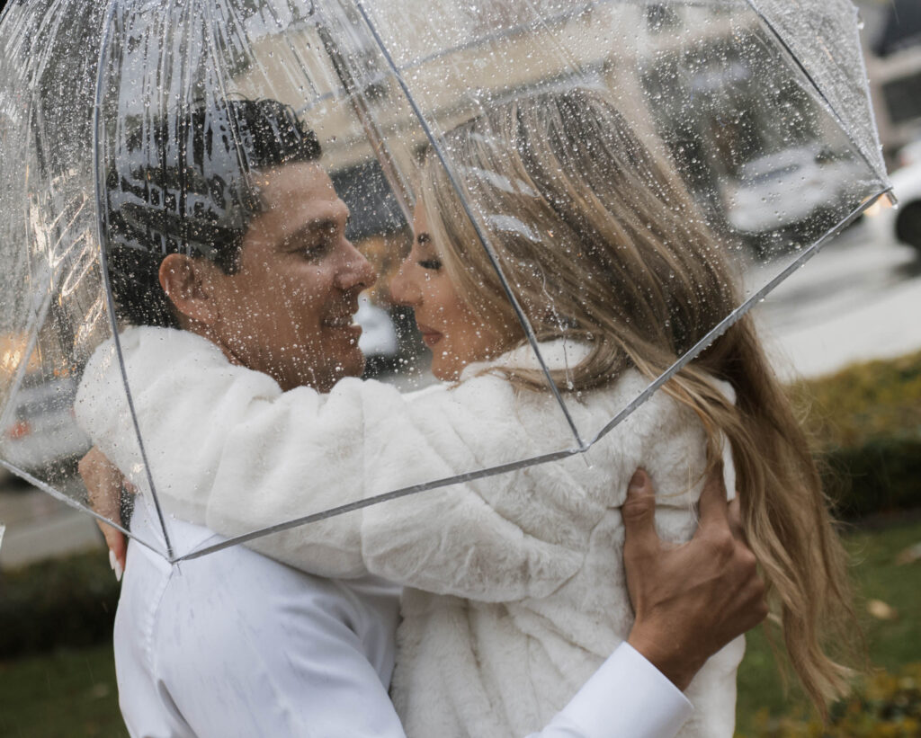 Couple walking through Historic Orange during a rainy engagement session with cinematic, romantic mood