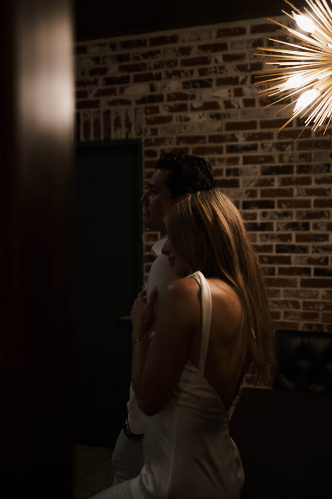 Cinematic engagement photography of couple laughing inside a cozy bar in Historic Orange
