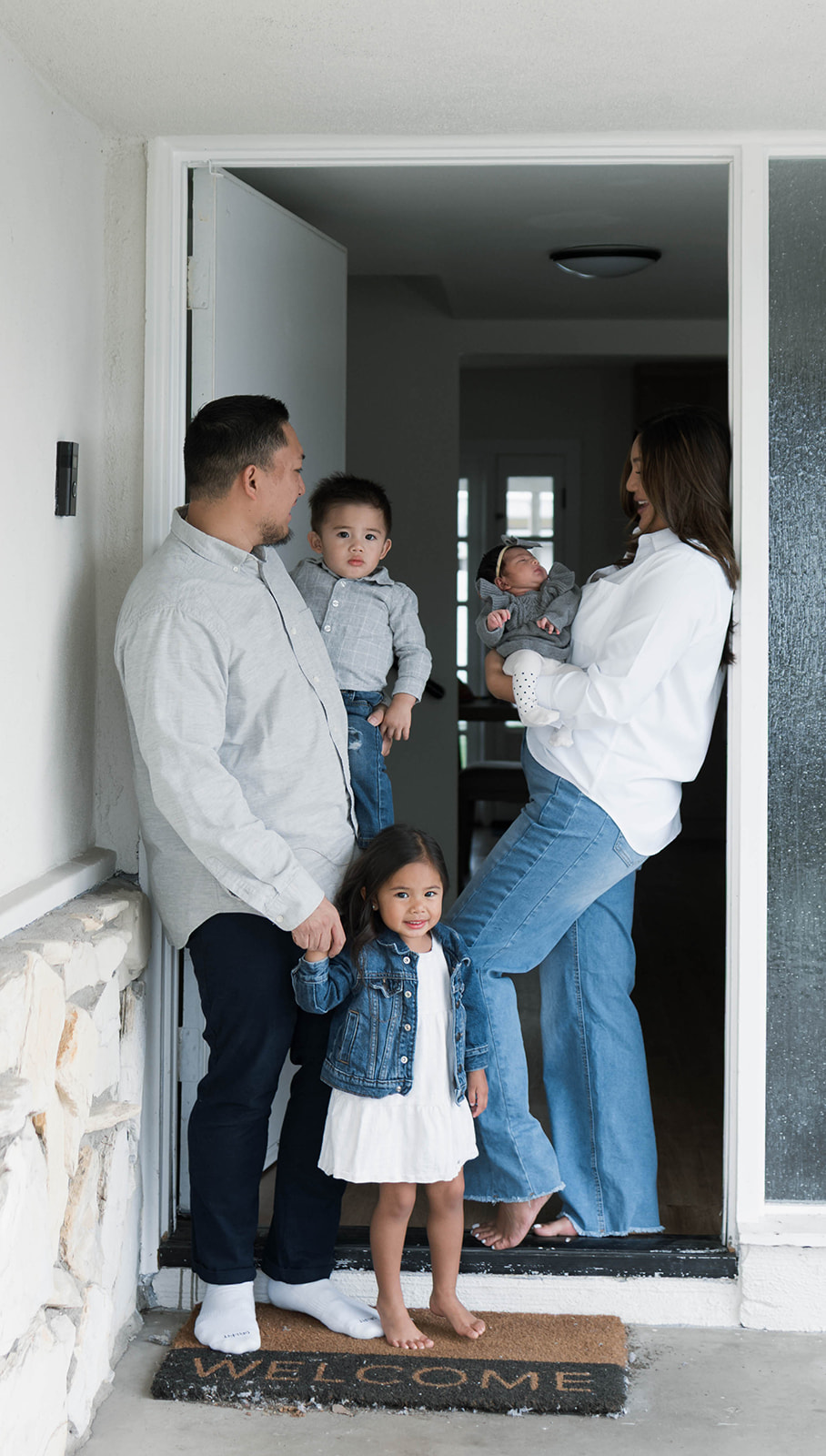 Young family of five standing in front of their forever home during an Orange County in-home family photography session