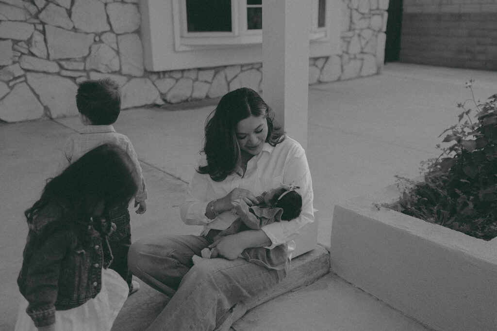 Young family of five standing in front of their forever home during an Orange County in-home family photography session