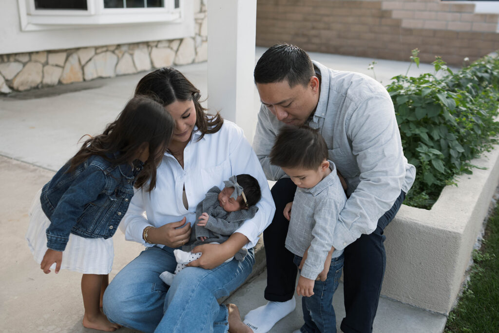 Young family of five standing in front of their forever home during an Orange County in-home family photography session