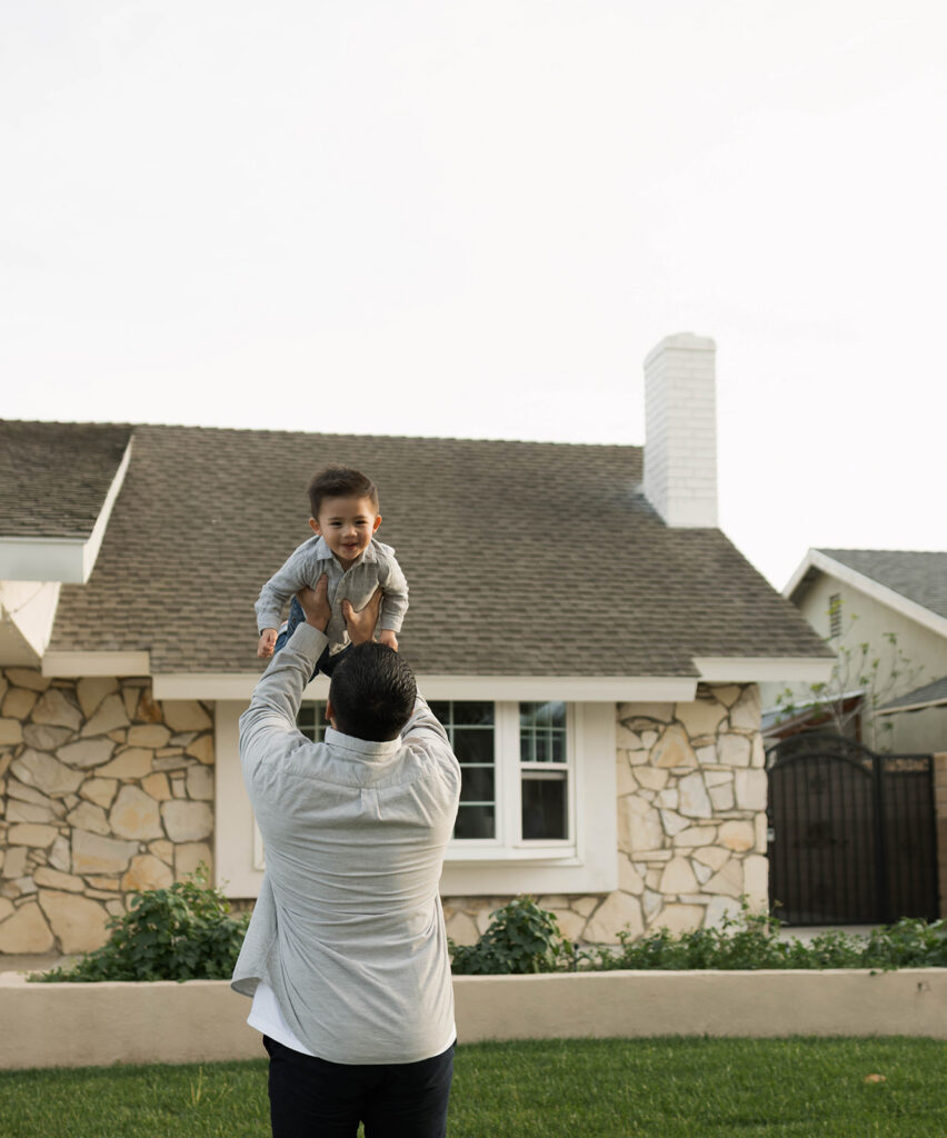 Young family of five standing in front of their forever home during an Orange County in-home family photography session