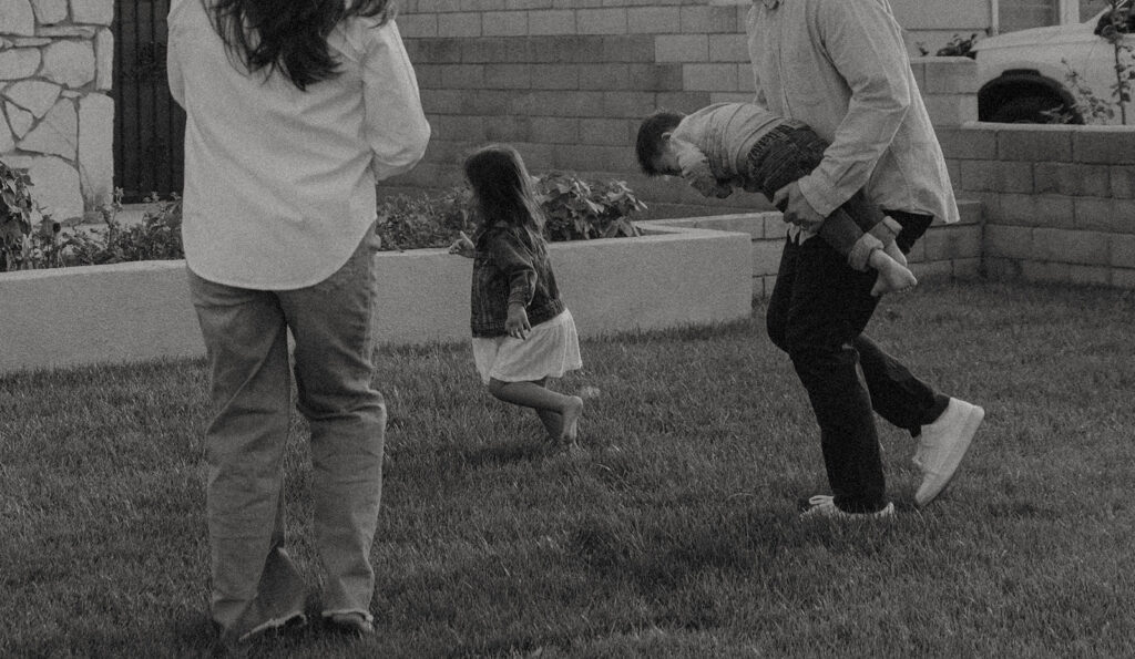 Young family of five standing in front of their forever home during an Orange County in-home family photography session