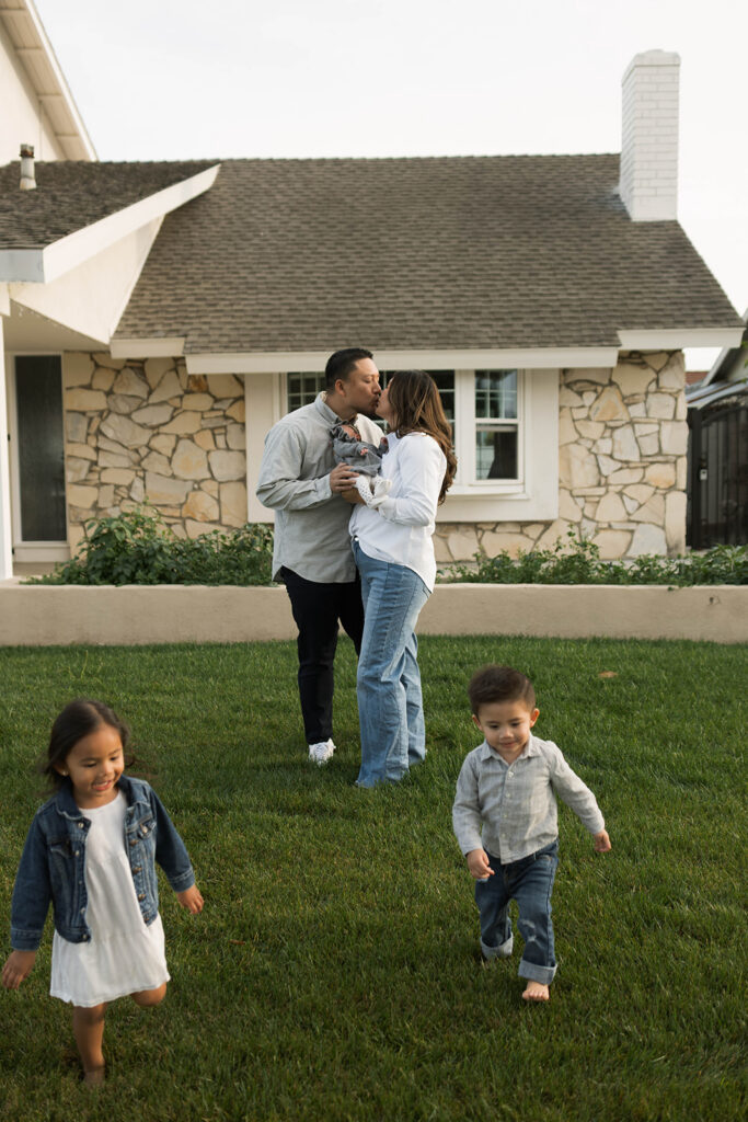 Young family of five standing in front of their forever home during an Orange County in-home family photography session