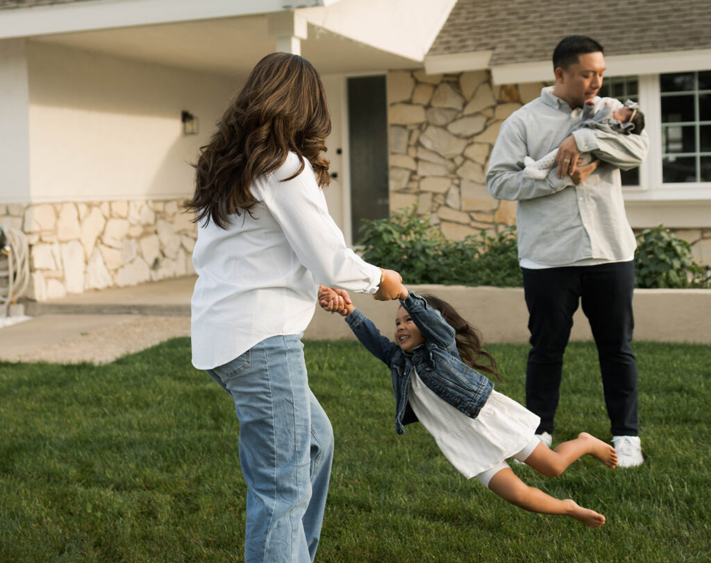Young family of five standing in front of their forever home during an Orange County in-home family photography session