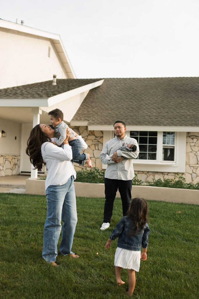 Young family of five standing in front of their forever home during an Orange County in-home family photography session