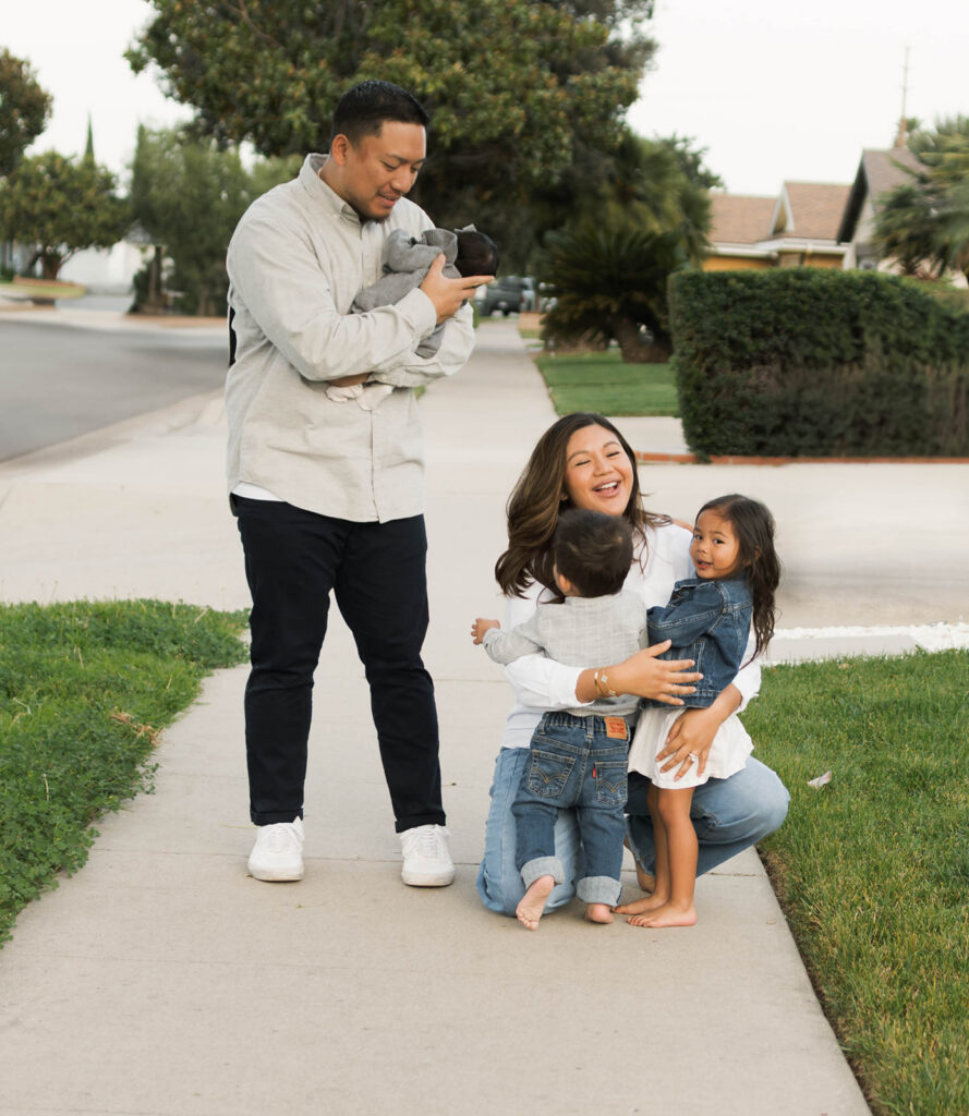 Young family of five standing in front of their forever home during an Orange County in-home family photography session