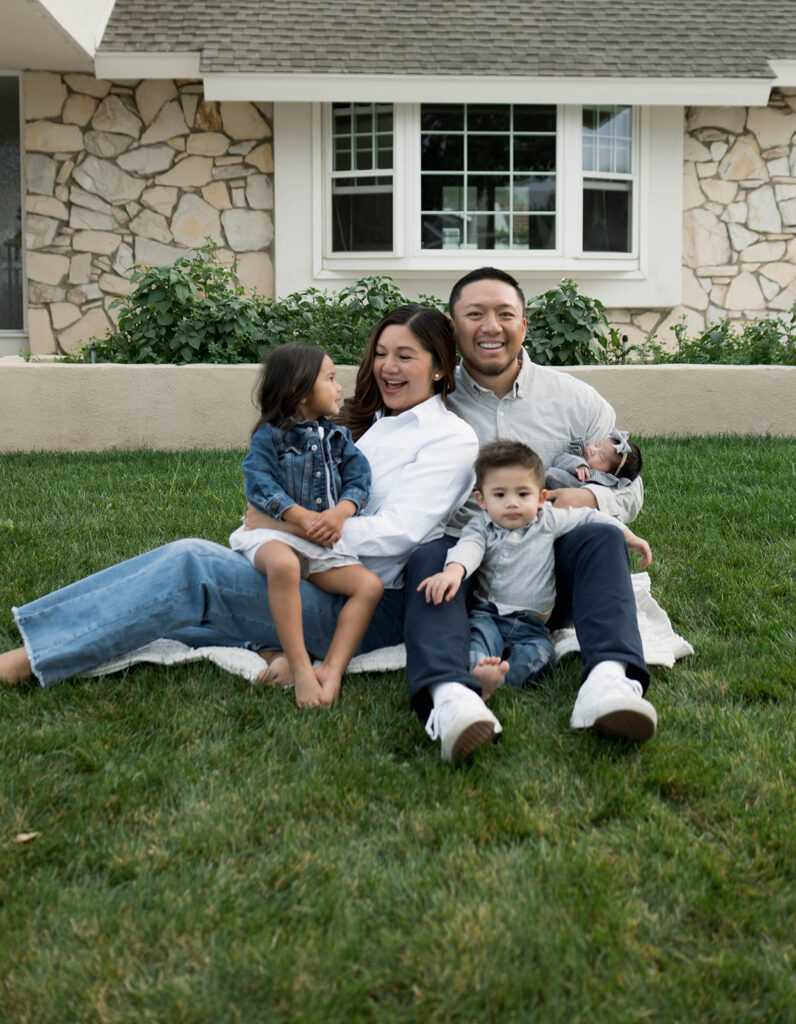 Young family of five standing in front of their forever home during an Orange County in-home family photography session