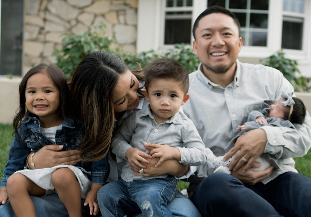Young family of five standing in front of their forever home during an Orange County in-home family photography session
