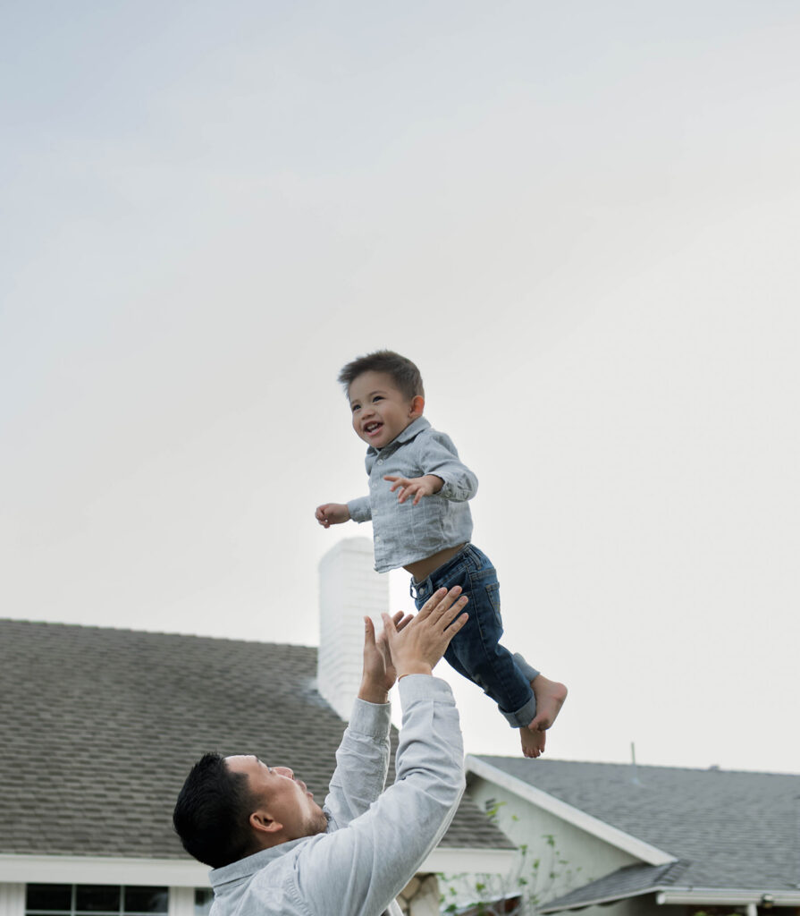 Young family of five standing in front of their forever home during an Orange County in-home family photography session
