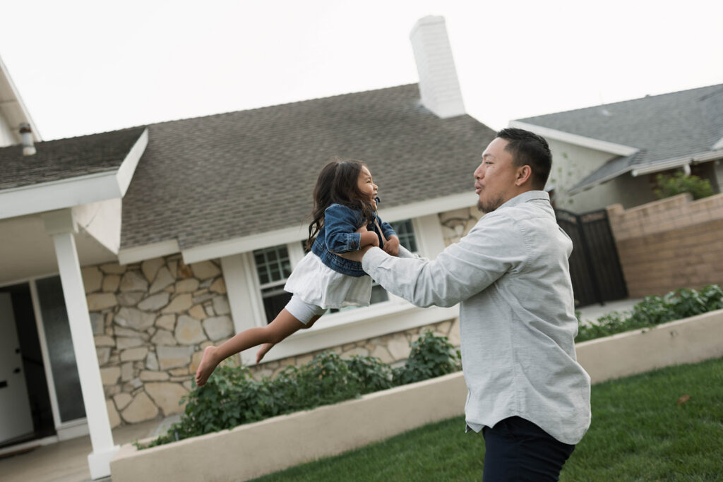 Young family of five standing in front of their forever home during an Orange County in-home family photography session
