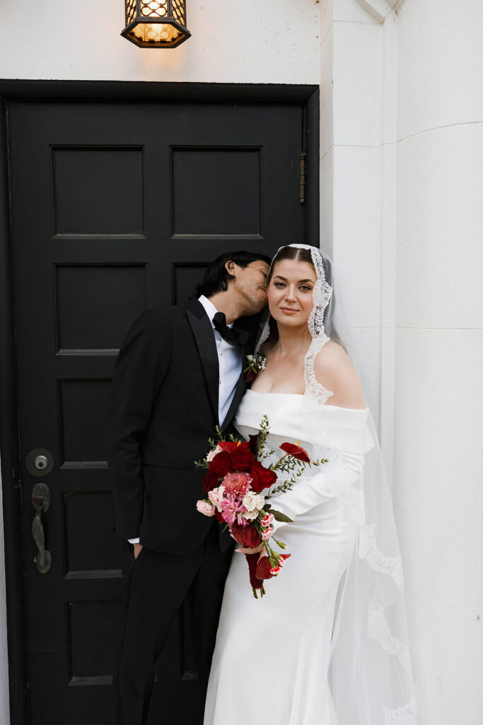 Bride and groom at a vintage-inspired wedding. groom kissing bride