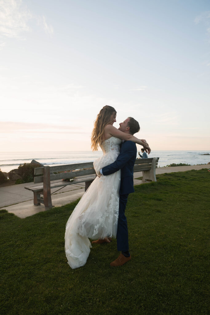 Intimate beach elopement ceremony with family gathered on a cliffside
