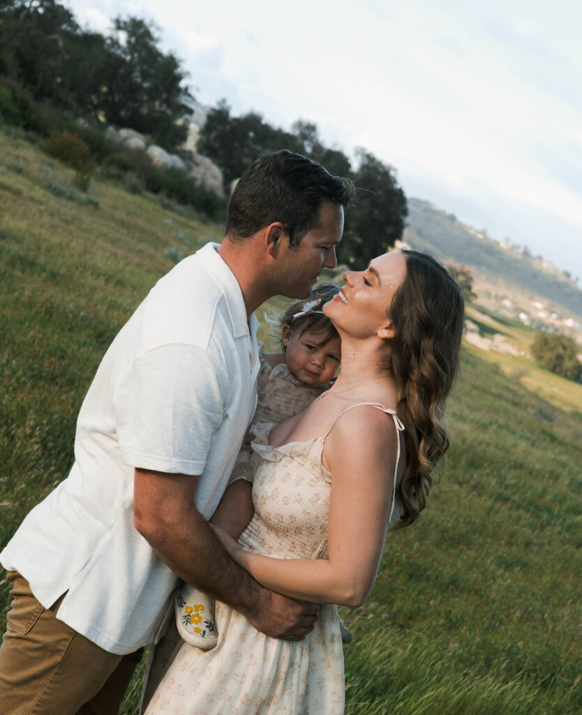 Candid moment of parents and child embracing in golden hour light