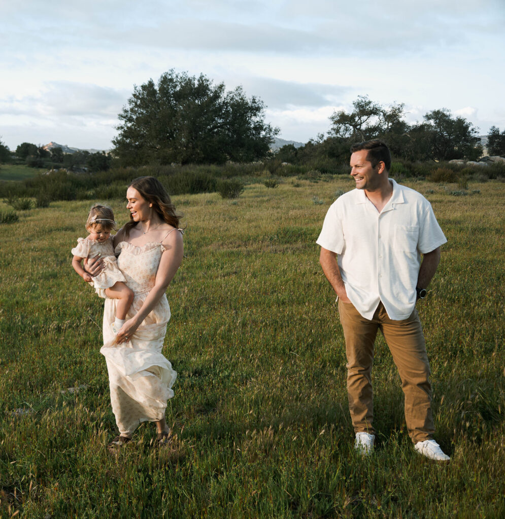 Candid moment of parents and child embracing in golden hour light