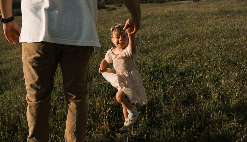 Candid moment of parents and child embracing in golden hour light