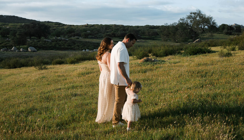 Candid moment of parents and child embracing in golden hour light