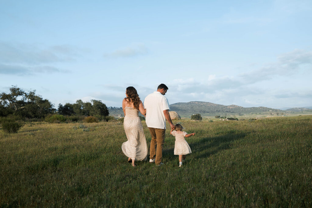 Candid moment of parents and child embracing in golden hour light