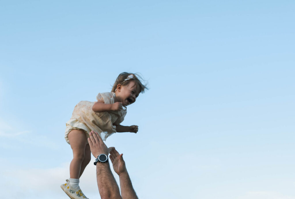 Candid moment of parents and child embracing in golden hour light