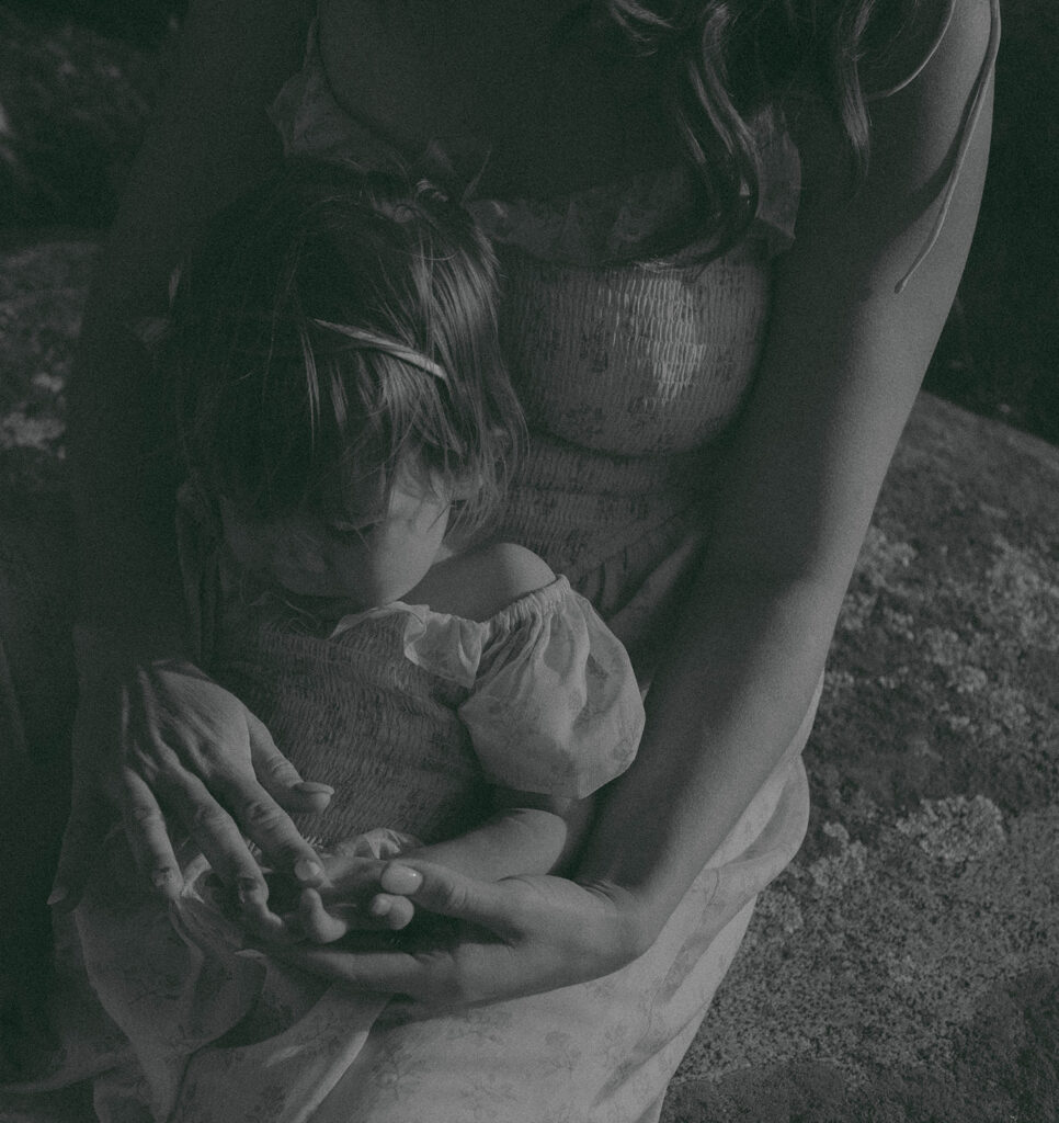 Candid moment of parents and child embracing in golden hour light
