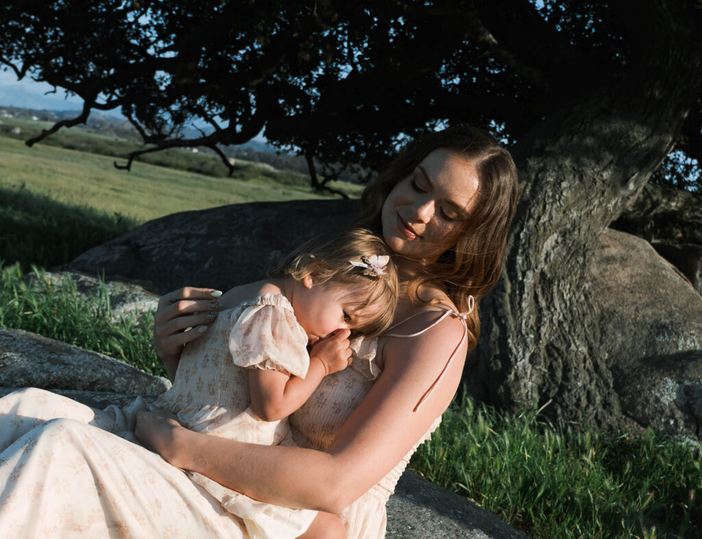 Candid moment of parents and child embracing in golden hour light
