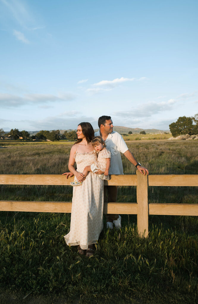 Candid moment of parents and child embracing in golden hour light