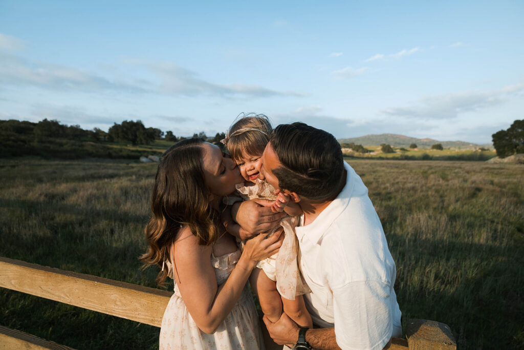 Candid moment of parents and child embracing in golden hour light