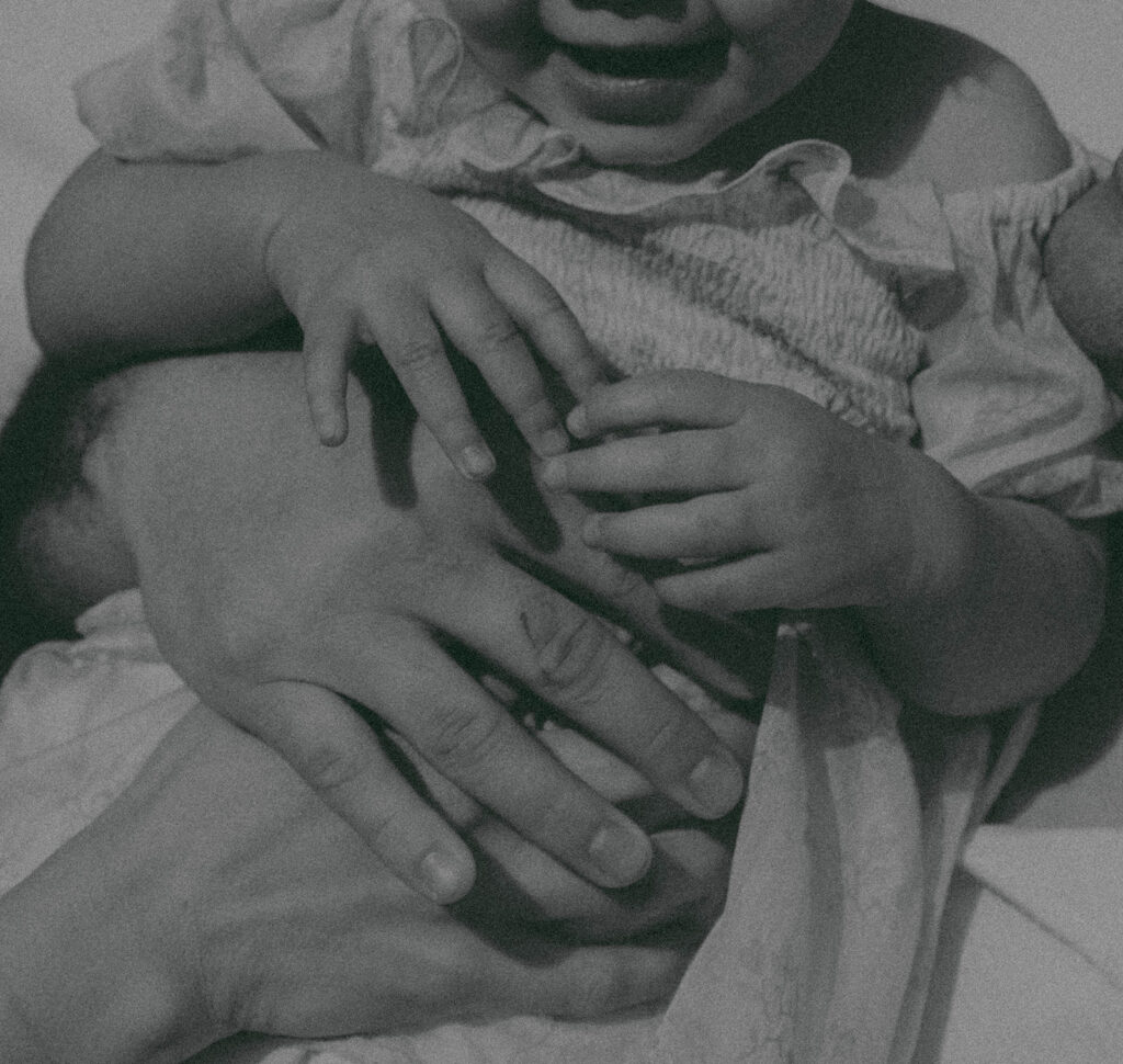 Candid moment of parents and child embracing in golden hour light