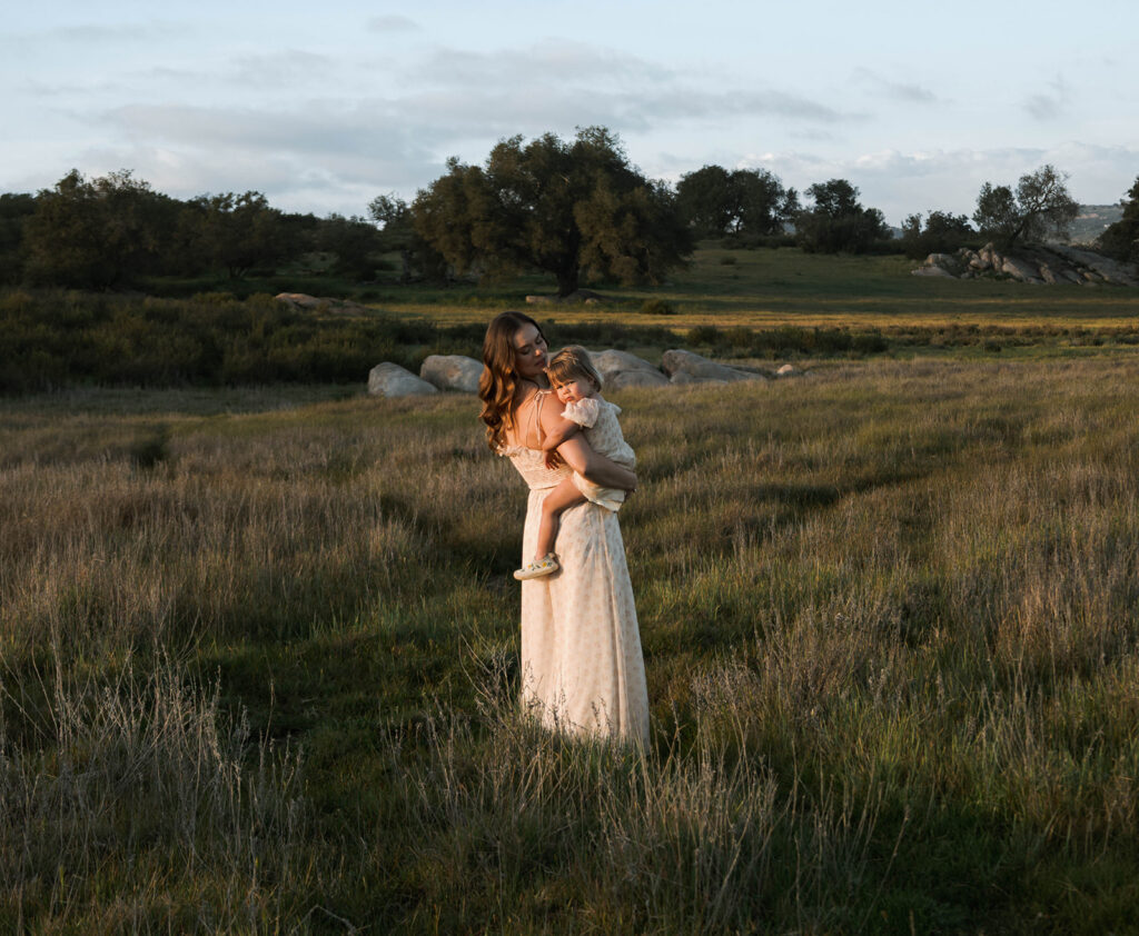 Candid moment of parents and child embracing in golden hour light