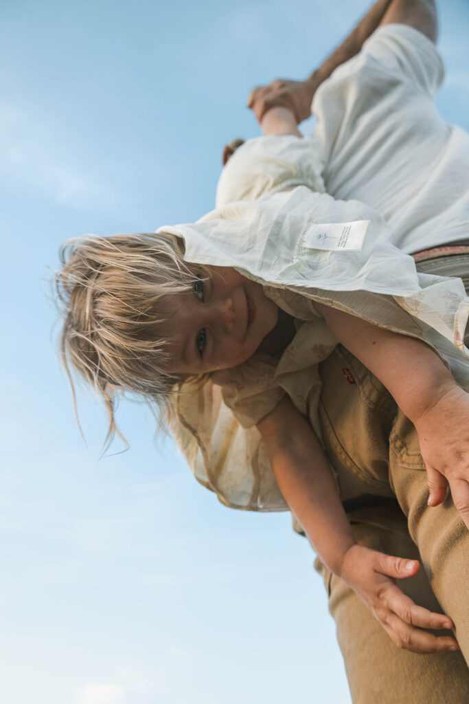 Candid moment of parents and child embracing in golden hour light