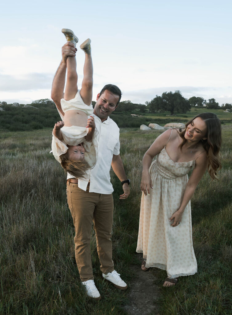 Candid moment of parents and child embracing in golden hour light