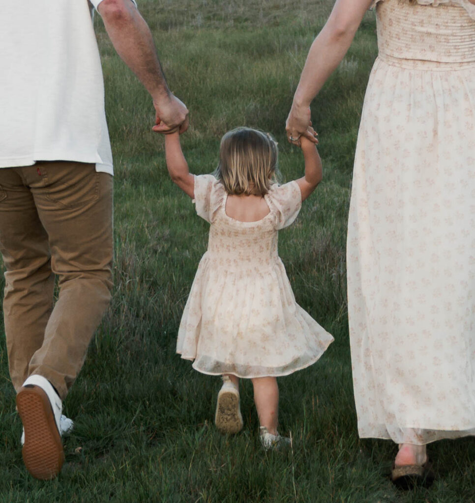Candid moment of parents and child embracing in golden hour light