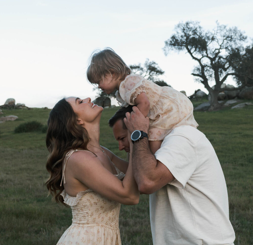 Candid moment of parents and child embracing in golden hour light
