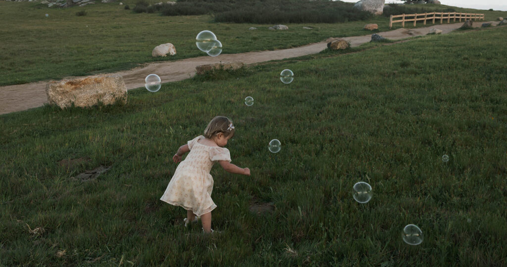 Candid moment child embracing in golden hour light with bubbles