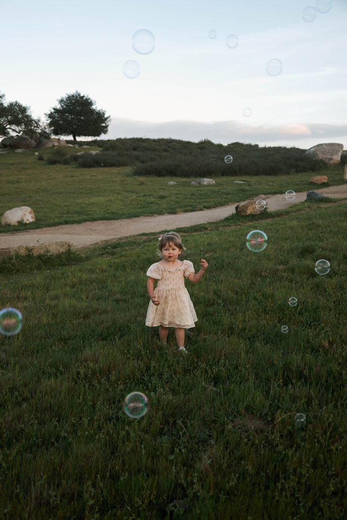 Candid moment child embracing in golden hour light with bubbles
