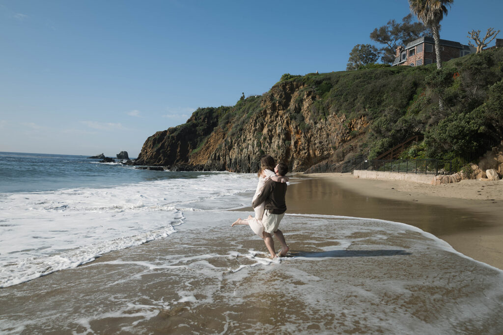 Cinematic film inspired engagement photos in Laguna Beach with Arizona couple in neutral outfits