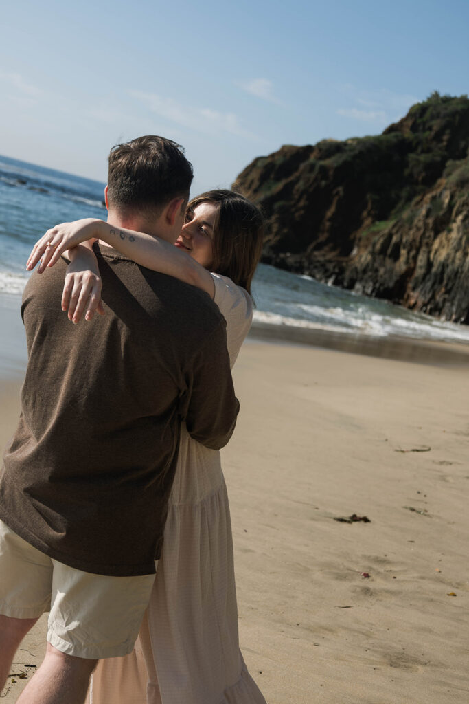 Cinematic film inspired engagement photos in Laguna Beach with Arizona couple in neutral outfits