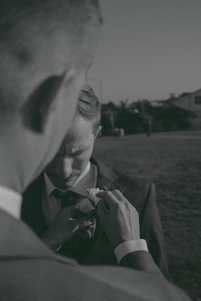 Intimate beach elopement ceremony with family gathered on a cliffside