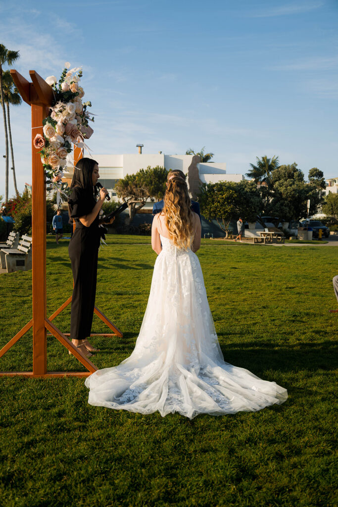 Intimate beach elopement ceremony with family gathered on a cliffside
