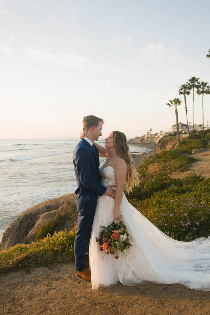 Intimate beach elopement ceremony with family gathered on a cliffside